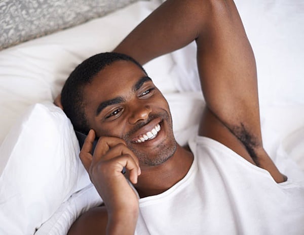 Black man on phone in bed - phone sex
