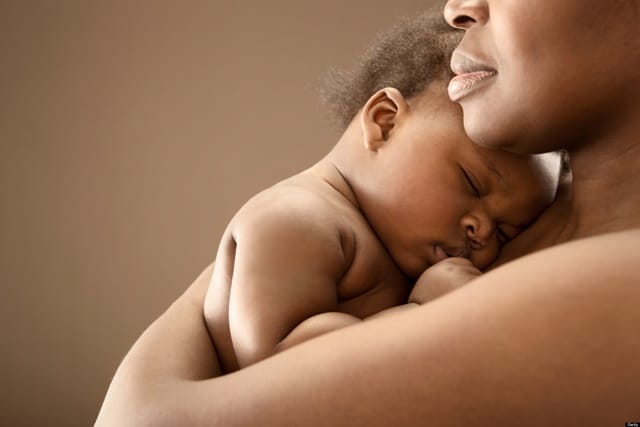 Black woman holding infant - ways to support new mom in your life