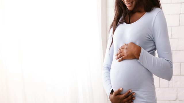 Pregnant black woman holding her belly