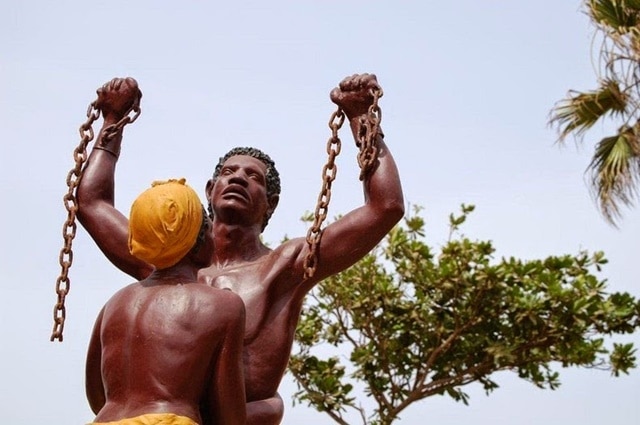 Sculpture of enslaved man with broken chains and woman next to him - Slave House Museum Senegal