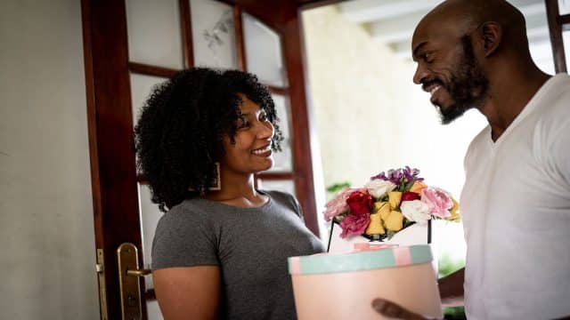 Black man handing a gift to his girlfriend