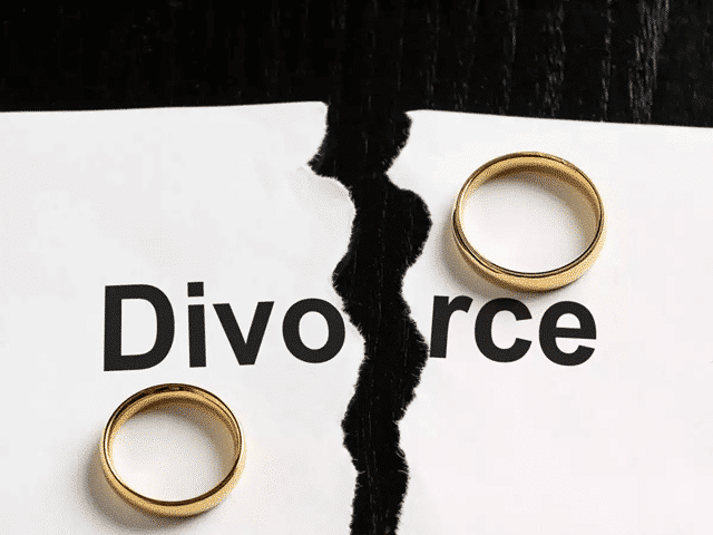 Word divorce on paper torn into two with a ring on each piece of paper