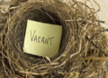 Empty bird nest with card with vacant written on it
